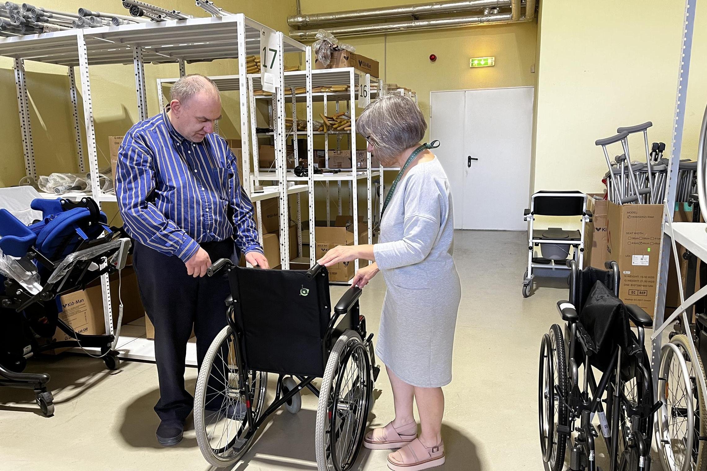 asmuo juda elektriniu vežimėliu, pritaiko vežimėlį
